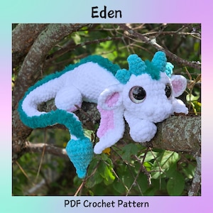 May include: A white and teal crochet dragon with large, dark eyes and pink-lined ears rests on a tree branch. The dragon has a long tail and teal accents. The word "Eden" is at the top, and "PDF Crochet Pattern" is at the bottom.