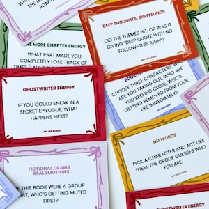 May include: A collection of colorful cards with various prompts and questions. Each card has a white background with text, framed by different colored borders, including red, orange, yellow, and purple. The cards are designed for interactive games or discussions.