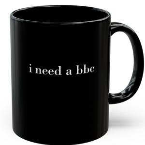 May include: A black ceramic coffee mug with a white text that reads "i need a bbc". The mug has a standard handle and a glossy finish. The mug is designed for hot or cold beverages.