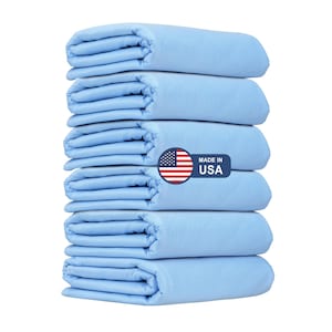 May include: A stack of eight light blue absorbent pads, folded and stacked neatly. The pads are made in the USA, as indicated by a red, white, and blue American flag sticker with the text "Made in USA".