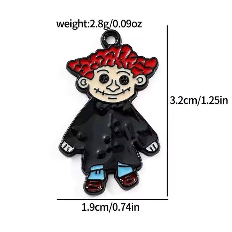 May include: A cartoon-style charm in the shape of a figure with red hair, black coat, and blue pants. The charm is 1.25 inches tall and 0.74 inches wide, weighing 0.09 ounces. The figure has a smiling face with button eyes.