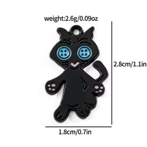 May include: A black cat charm with blue button eyes and pink accents. The charm is 1.1 inches tall and 0.7 inches wide, weighing 0.09 ounces. The charm has a loop at the top for attaching to a necklace or bracelet.