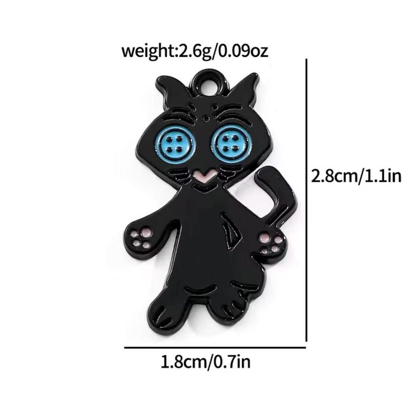 May include: A black cat charm with blue button eyes and pink accents. The charm is 1.1 inches tall and 0.7 inches wide, weighing 0.09 ounces. The charm has a loop at the top for attaching to a necklace or bracelet.
