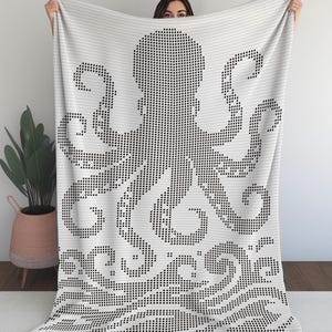 May include: White blanket featuring a black octopus design. The octopus is created using a dot pattern, with its tentacles and head prominently displayed. The blanket has a decorative wave pattern at the bottom.