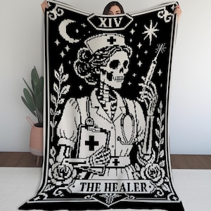 May include: A black and white rectangular throw blanket featuring a pixel art design of a skeleton nurse in a uniform and cap. The figure holds a syringe and a clipboard with a cross symbol. The text XIV and THE HEALER appear on the blanket.