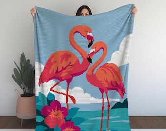 Peut inclure: Un plaid rectangulaire orné d'un motif pixélisé représentant deux flamants roses vifs se faisant face sur un ciel bleu clair avec des nuages blancs. Le premier plan présente un feuillage bleu sarcelle et deux fleurs d'hibiscus roses.