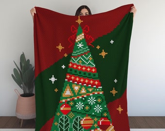May include: A red and green knitted throw blanket with a pixelated Christmas tree design. The tree is decorated with ornaments, stars, and a bow.