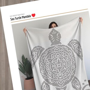 May include: A white blanket featuring a black sea turtle mandala design. The blanket is held up, displaying the intricate pattern. Text at the top reads "FILET CROCHET Digital Pattern" and "Sea Turtle Mandala".