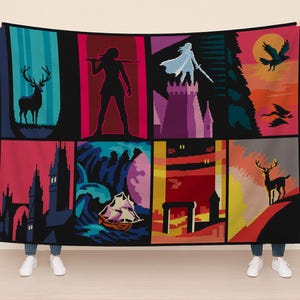 May include: A black blanket featuring a colorful, geometric design with various scenes. The scenes include a deer, a figure with a spear, a figure with a sword on a castle, and a ship on the sea. The blanket is held up by a person.