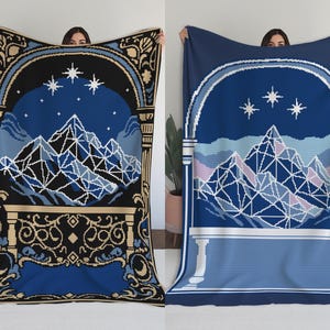Puede incluir: Dos mantas con diseños de montañas y estrellas. Una manta es negra, azul y beige, con un arco detallado y un borde decorativo. La otra es azul y blanca, con un arco y un borde más simples. Ambas presentan cadenas montañosas geométricas.