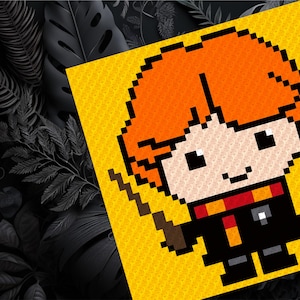 May include: A pixel art illustration of a red-haired character with a wand, wearing a black robe with a red and yellow scarf. The character is on a yellow background.