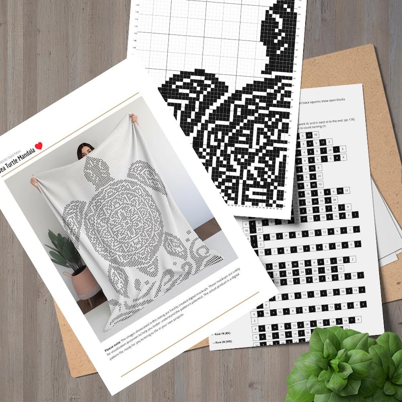 May include: A white blanket with a black and white sea turtle mandala design. The blanket is held up, with a plant and cross-stitch pattern charts in the background. The text "Sea Turtle Mandala" is visible.