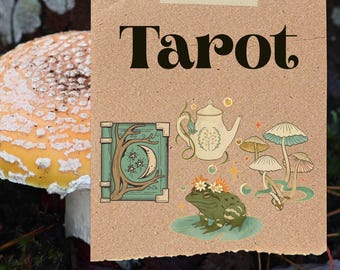 May include: A square piece of tan paper with the word Tarot printed in black at the top. The paper features illustrations of a green book with a moon and stars, a cream teapot, a green frog with flowers, and mushrooms. Toadstool Witchery is below.