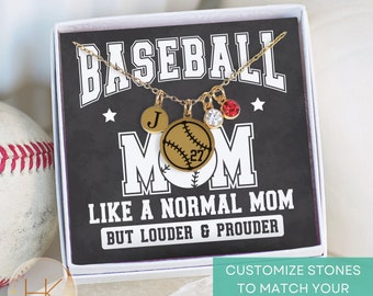 May include: A gold necklace with a baseball charm, a letter charm, and red and clear crystal charms. The necklace is in a white box with a black background that says "Baseball Mom Like a Normal Mom But Louder & Prouder". The box also says "Customize Stones to Match Your Teams Colors".
