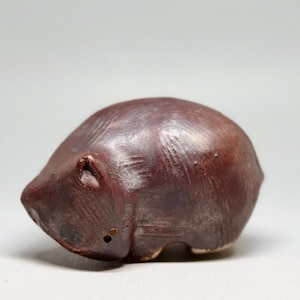 May include: A white ceramic mug with a black handle and the text "But First, Coffee" in a bold, black font. The mug is set against a neutral background, highlighting its simple design.