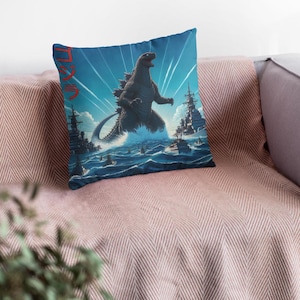 May include: A blue and white throw pillow with a black and white illustration of Godzilla standing in the ocean with ships in the background. The text "ゴジラ" is written in red on the pillow.
