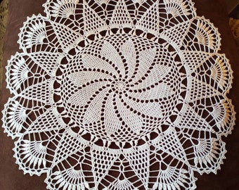 May include: White crocheted doily with a circular design and a spiral pattern in the center.