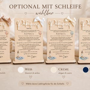 May include: Four rectangular wooden plaques with stands, each featuring the German text Patenbrief, a lighthouse illustration, a hot air balloon, and a fabric bow in nude, white, cream, or navy blue. The plaques display personalized details.