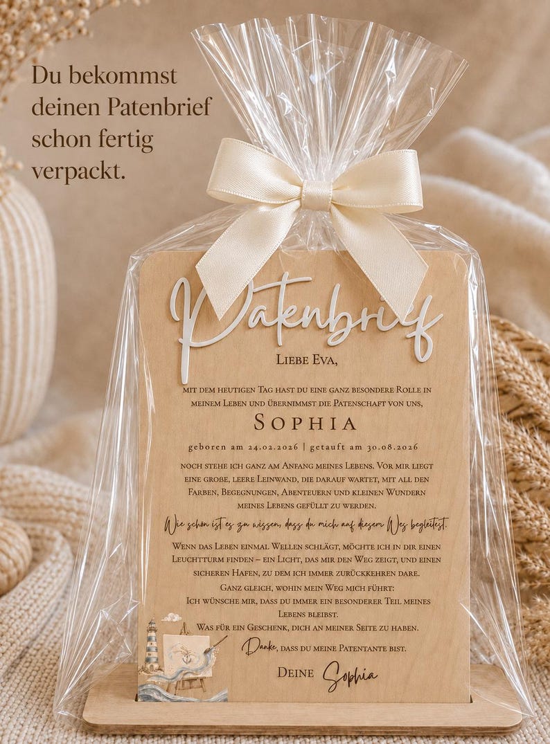 May include: A wooden plaque with the German text Patenbrief and a heartfelt message for a godparent, featuring a lighthouse illustration. The plaque is encased in a clear plastic bag tied with a cream-colored satin ribbon bow.