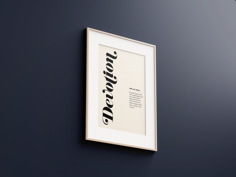 May include: A framed print with the word "Devotion" in a stylized font. The print includes a definition of the word, which reads: "A state of mind that produces a willingness of the soul to acknowledge a higher power and to surrender to its influence with absolute trust, loyalty and faithfulness. It is a state of mind that becomes a virtue, while it produces a spiritual energy that becomes evident in our relationships."