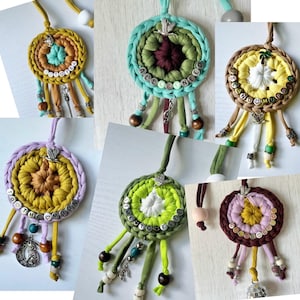 May include: Six crocheted dreamcatchers with colorful yarn and beads. Each dreamcatcher has a different phrase spelled out with letter beads. The phrases are "All I Need", "To The Moon", "Just To Fly", "Island Vibes", "Together", and "Forever".