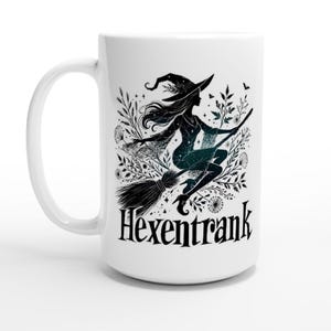 May include: White ceramic mug with a black silhouette of a witch flying on a broomstick with the text "Hexentrank" printed on the mug.