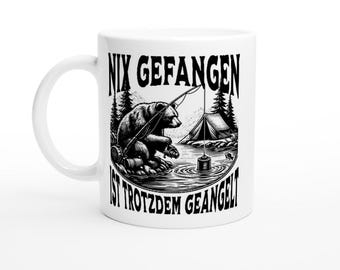 May include: White ceramic mug with a black and white illustration of a bear fishing. The text "Nix gefangen ist trotzdem geangelt" is printed on the mug.