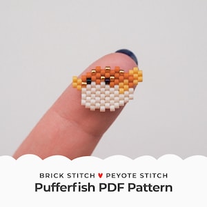 May include: A small, white, orange, and yellow beaded pufferfish charm. The charm is made using brick stitch and peyote stitch beading techniques. The charm is on a finger, and the text "BRICK STITCH ♥ PEYOTE STITCH Pufferfish PDF Pattern" is below the image.