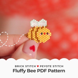 May include: A beaded bee charm in yellow, brown and white with a cute face. The charm is made using brick stitch and peyote stitch beading techniques. The charm is held by a finger with a red heart nail design. The text "BRICK STITCH ♥ PEYOTE STITCH Fluffy Bee PDF Pattern" is at the bottom of the image.