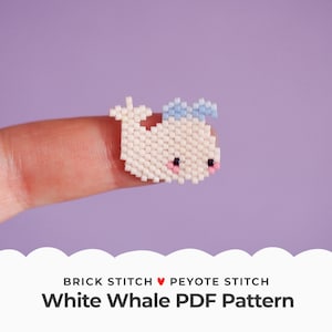 May include: A white whale bead sprite with a blue bow, made with brick stitch and peyote stitch. The bead sprite is on a finger, with a purple background. The text "Brick Stitch ♥ Peyote Stitch White Whale PDF Pattern" is below the image.