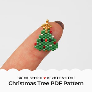 Puede incluir: Una cuenta de árbol de Navidad verde con cuentas rojas y plateadas, una estrella dorada en la parte superior y un patrón de punto de ladrillo y punto de peyote. Patrón de árbol de Navidad en PDF.