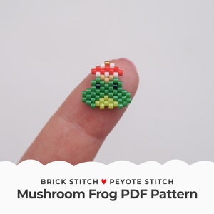 Könnte beinhalten: Ein grüner und gelber Perlenfrosch mit einem roten und weißen Pilz-Hut. Der Frosch ist mit Brick Stitch und Peyote Stitch Perlen-Techniken hergestellt. Der Text "BRICK STITCH ♥ PEYOTE STITCH Mushroom Frog PDF Pattern" befindet sich unter dem Frosch.