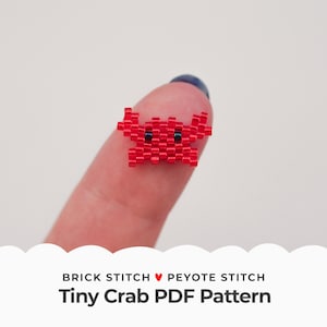 Peut inclure: Un petit crabe rouge en perles avec des yeux noirs. Le crabe est tenu sur un doigt. Le texte "Brick Stitch ♥ Peyote Stitch Tiny Crab PDF Pattern" est sous l'image.