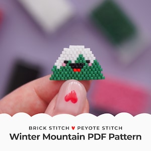 May include: A green and white beaded mountain with a smiling face. The mountain is made with brick stitch and peyote stitch. Winter Mountain PDF Pattern.