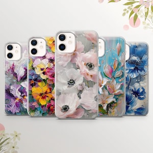 May include: Five different phone cases with floral designs. The cases feature a variety of flowers, including irises, pansies, and anemones, in shades of purple, yellow, pink, and white. The cases are all clear and show the phone's design through the back.