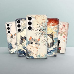 Könnte beinhalten: Fünf verschiedene Handyhüllen mit Katzenmotiv. Die Hüllen sind alle weiß mit verschiedenen bunten Designs mit Katzen, Blumen und Wellen. Die Hüllen sind alle für ein Handy mit einem Dreifach-Kamerasystem.