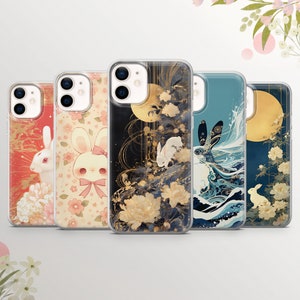 Puede incluir: Una colección de cinco fundas para teléfono con diseños únicos. Las fundas muestran ilustraciones de conejos, flores y lunas en varios estilos, incluyendo patrones florales y representaciones artísticas. La paleta de colores incluye rojo, rosa, azul, dorado y negro.