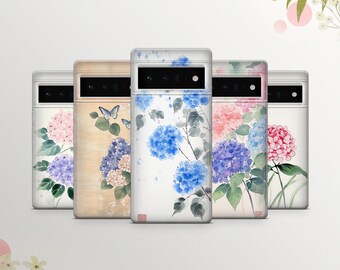 May include: Five phone cases with different floral designs. Each case features a watercolor painting of blue and pink hydrangeas with green leaves. The cases are all white with a black camera cutout.