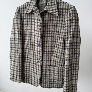 May include: A vintage blazer in a green, black, and tan plaid pattern. The jacket has a notched collar, three buttons, and two front pockets. The River Island label is visible on the hanger.