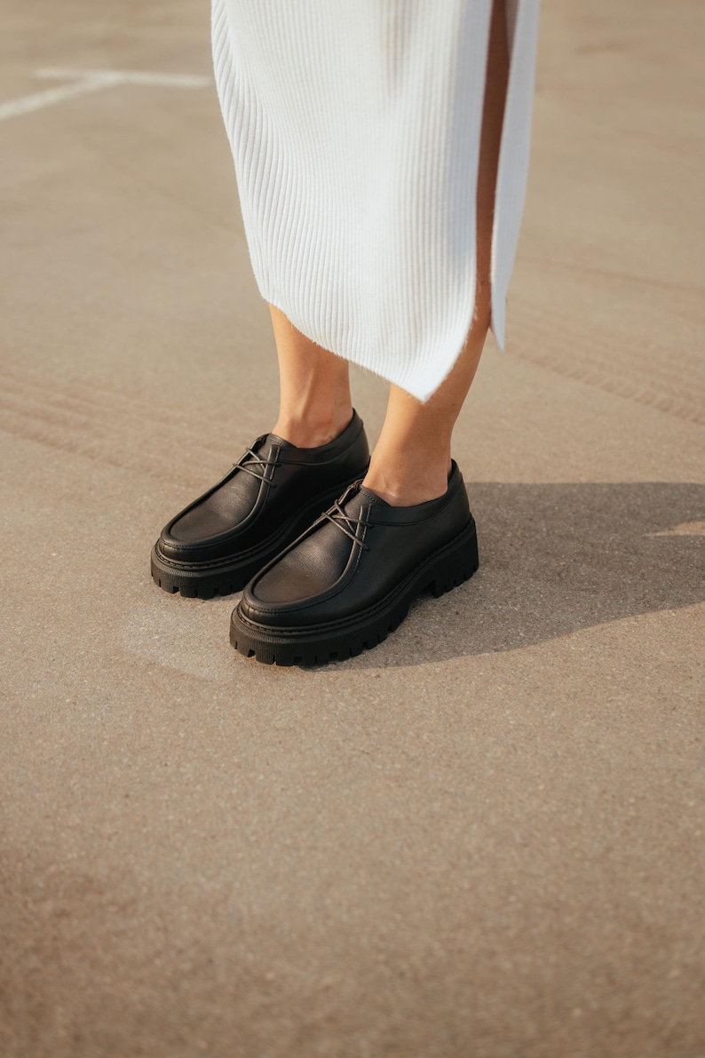 May include: Black leather lace-up shoes with a chunky platform sole.