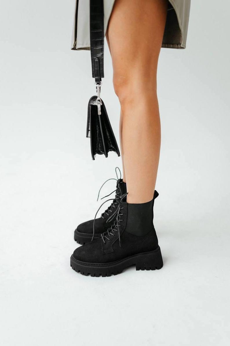 May include: Black suede lace-up ankle boots with a chunky platform sole.