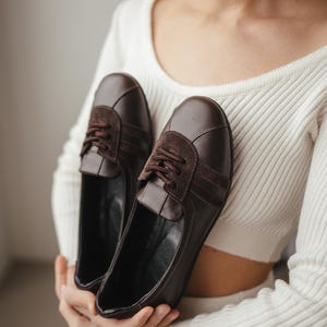 Top-down view of women's brown leather ballet flats with suede inserts, showing the wide toe design and sporty style, on a clean background