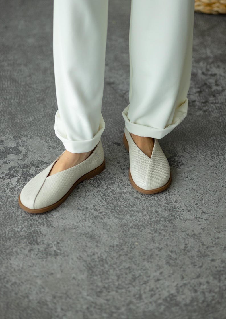 Women’s wide toe leather flats with decorative leather overlay.