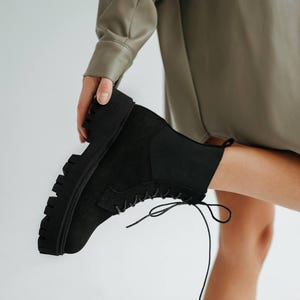 Stylish black boots with decorative elastic insert and light sole