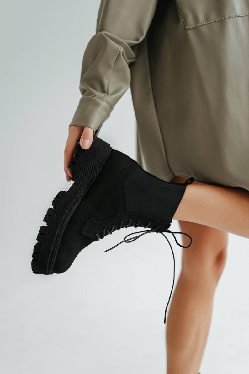 Stylish black boots with decorative elastic insert and light sole