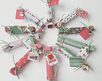 May include: A festive arrangement of Christmas crackers, each wrapped in patterned paper with red, green, and white designs. The crackers are decorated with tags and embellishments, creating a cheerful holiday display. The crackers are arranged in a circular pattern.