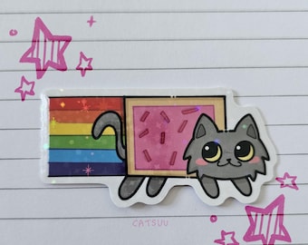 May include: A sticker featuring a gray cat with large eyes, a rainbow tail, and a pink rectangular body with sprinkles. The sticker has a holographic effect and is surrounded by pink star doodles. The text "catsuu" is at the bottom.