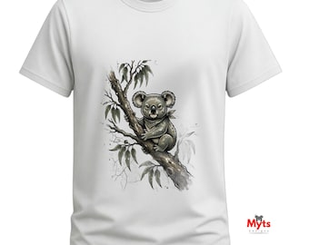 May include: A white short-sleeved t-shirt featuring a graphic illustration of a grey koala perched on a brown tree branch with green leaves. The shirt has a crew neckline and includes the text Myts Designs printed on the collar and bottom right.