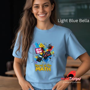 May include: Light blue Bella t-shirt featuring a colourful graphic of mathematical tools and the text "Marvel at the MATH".