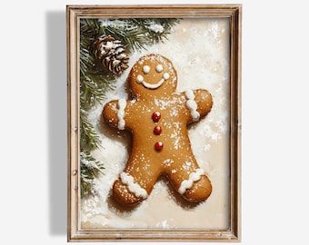 May include: A framed print of a gingerbread man with white icing and red button details. The artwork includes a pine cone and evergreen branches, set against a snowy background. The frame is a light brown colour.